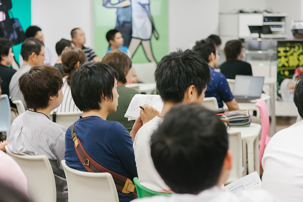 真剣にメモをとる聴衆